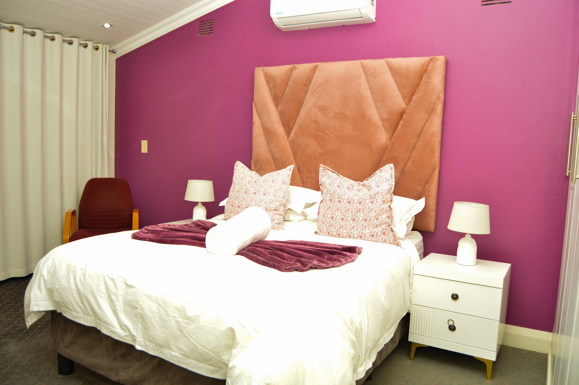 Room Four at Yellowwoods Bed & Breakfast with an upholstered headboard and warm lighting