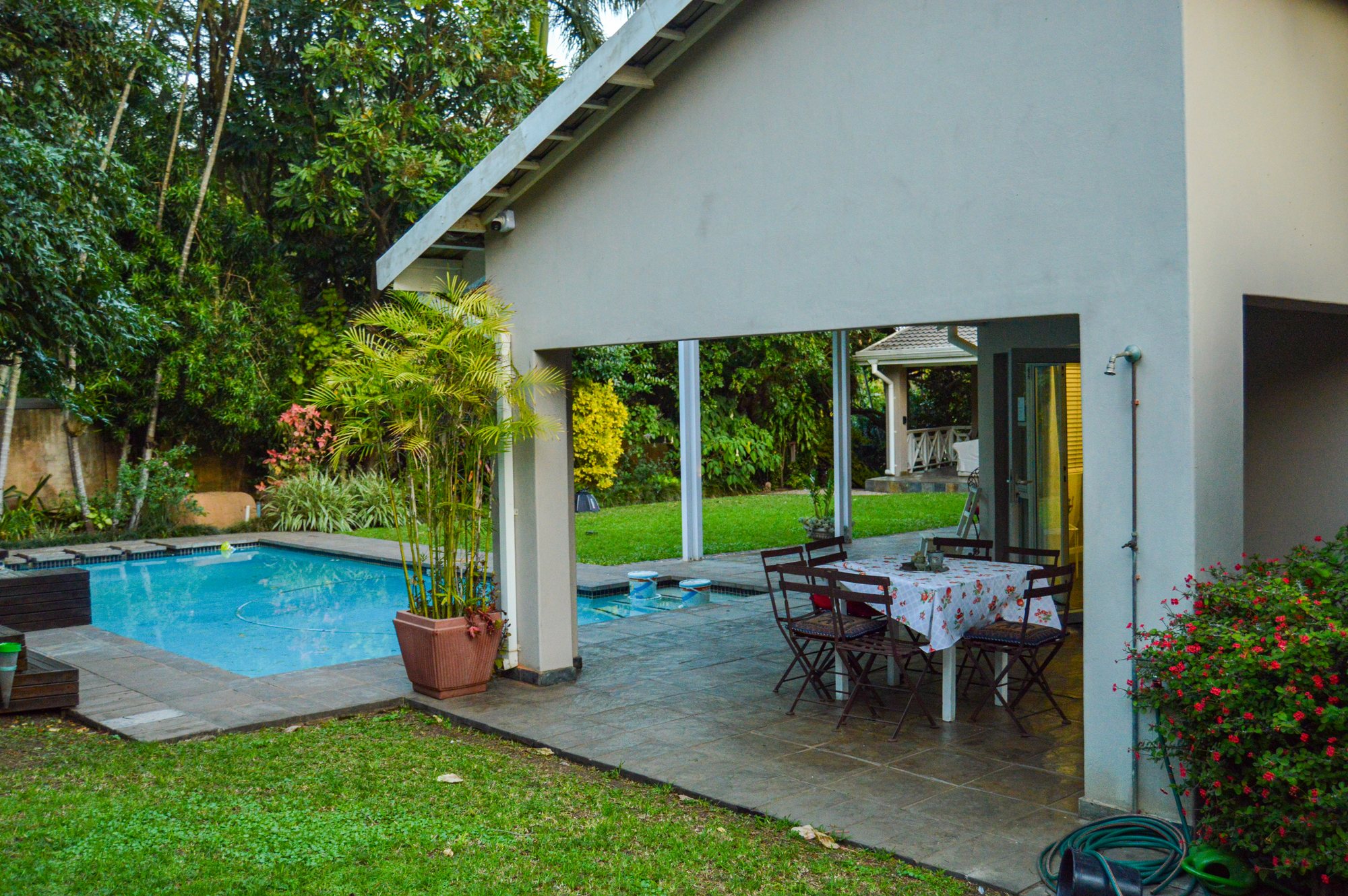 Covered patio and outdoor dining table beside the pool at Yellowwoods